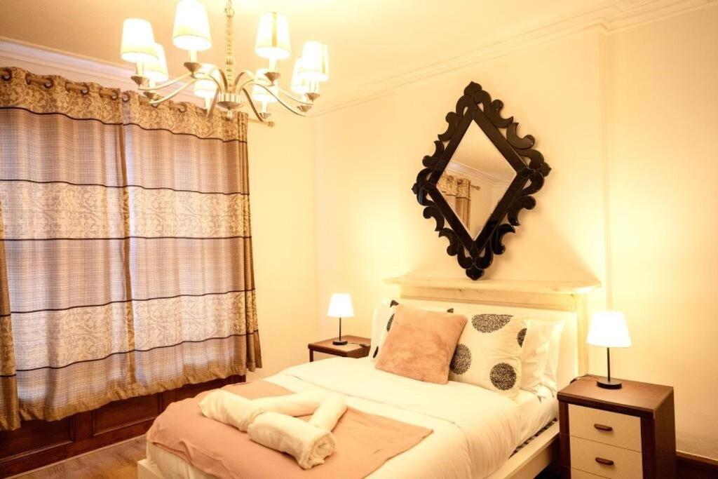 a bedroom with a bed with a mirror on the wall at Spacious 2 Bedroom Flat in London