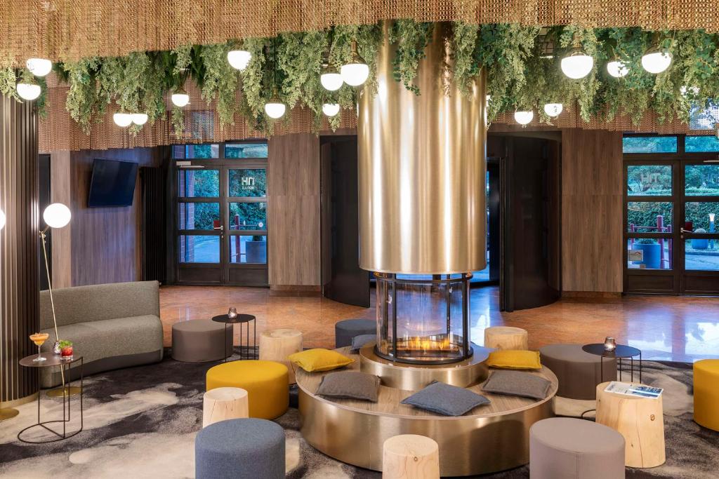 a lobby with a fountain in the middle of a room at NH Geneva Airport Hotel in Geneva