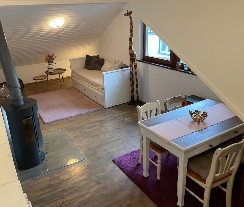 uma sala de estar com uma mesa e um quarto com um sofá em Wohnung in idyllischem Örtchen em Meschede