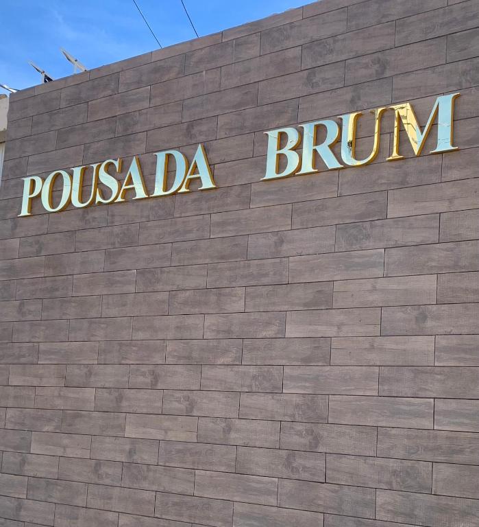 a sign on the side of a brick building at Pousada Brum in Pelotas