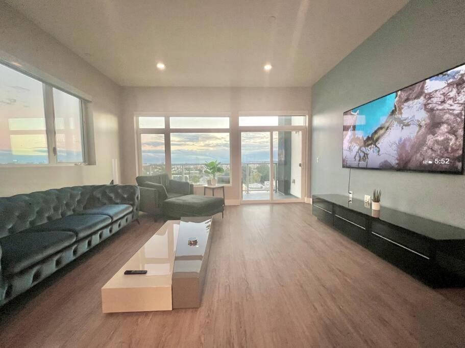 a living room with a couch and a flat screen tv at Luxe Corner Penthouse 1BR Condo on Sunset in Los Angeles
