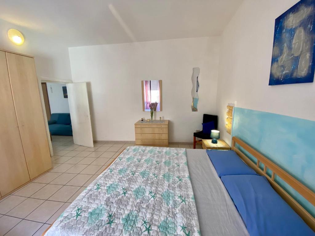 a room with a bed and a blue couch at Appartamento Via Marinedda 9 Isola Rossa in Isola Rossa