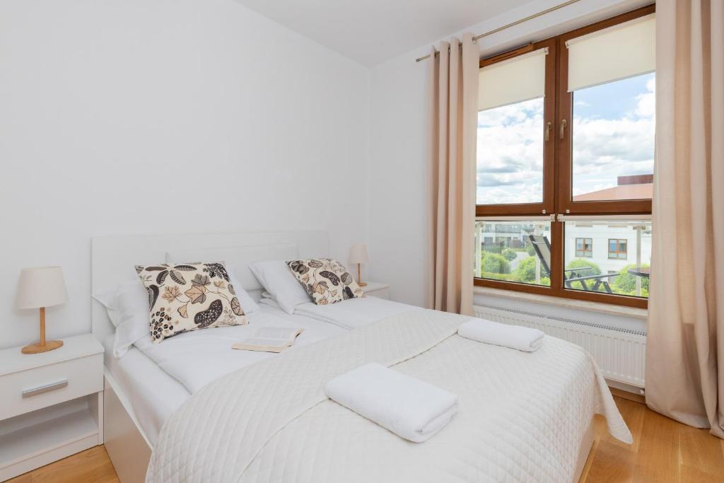 biała sypialnia z łóżkiem i oknem w obiekcie Beautiful Apartment Gdynia Czarnieckiego with Balcony by Renters w mieście Gdynia