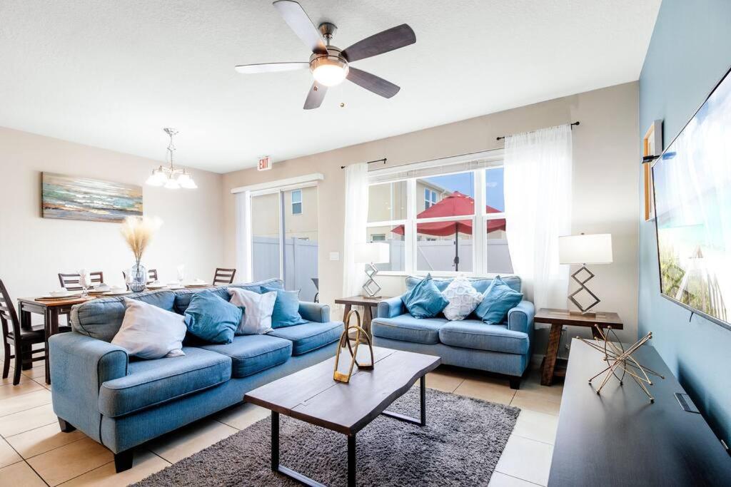 a living room with blue couches and a table at 5 mins from Disney, Family Friendly Townhome in Kissimmee
