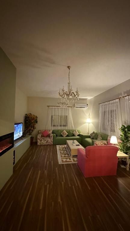 艾卜哈فيلا ممشى الضباب的客厅配有绿色沙发和红色椅子