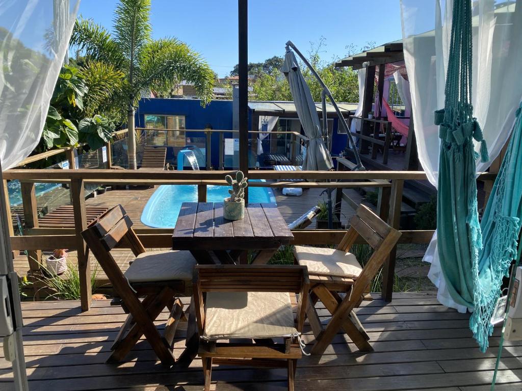 インビトゥバにあるCasa Container Praia do Rosa - 01 Ibiraqueraの木製デッキ(テーブル、椅子付)、プール