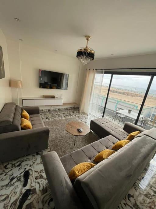 een woonkamer met 2 banken en een groot raam bij Appartement neuf/vue sur mer in Yof