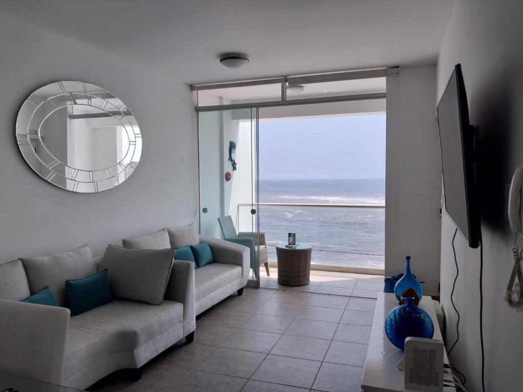 - un salon avec un canapé et une vue sur l'océan dans l'établissement Departamento en Punta Hermosa con vista al Mar, à Punta Hermosa