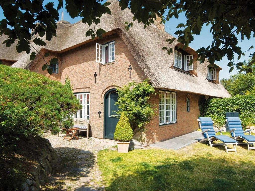 une maison avec des chaises et un toit de chaume dans l'établissement Dorfaue, à Kampen