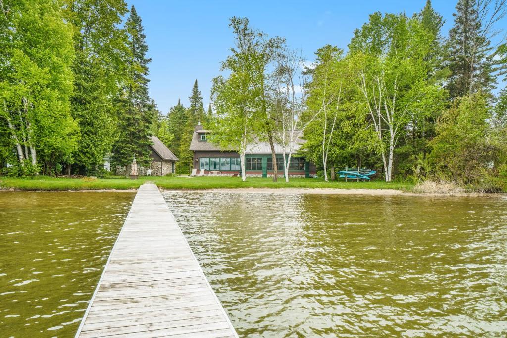 a dock in front of a house on a lake at Platte Lake Paradise in Beulah