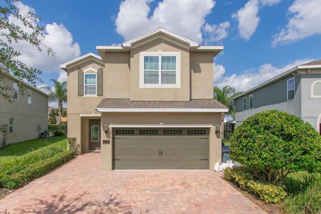 a house with a garage in a driveway at Luxury 6 BR 6 Bath @Encore Resort Pool Spa Grill. in Orlando