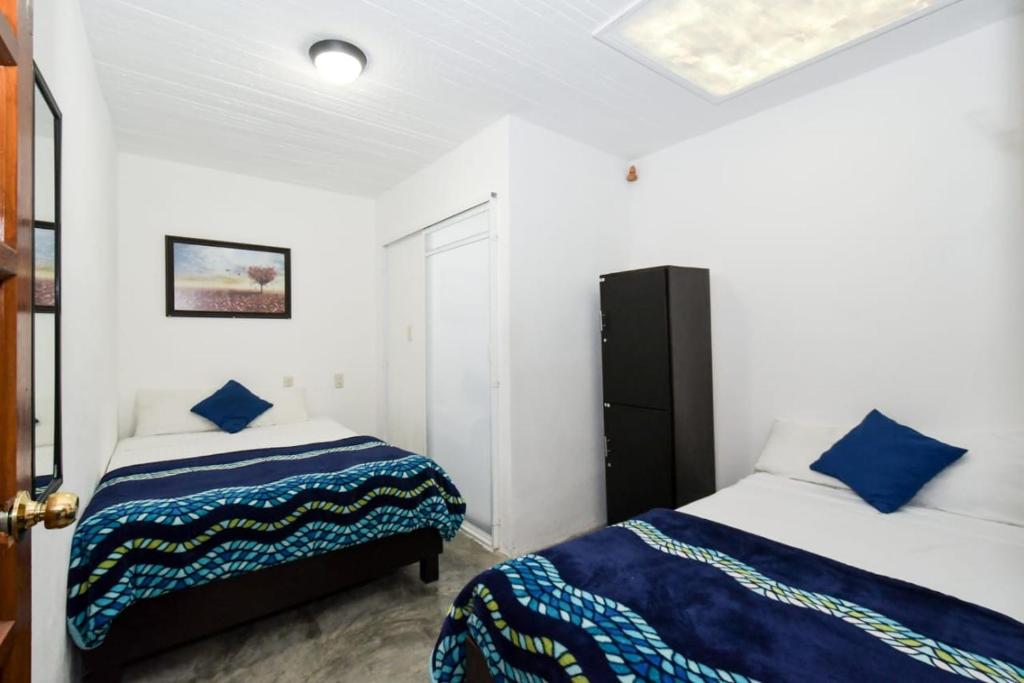 - une chambre avec 2 lits dotés d'oreillers bleus dans l'établissement Casa Morenita mía, à San Cristóbal de Las Casas