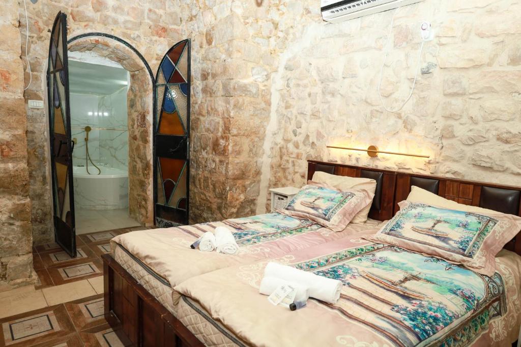 a bedroom with a bed and a bathroom with a mirror at אורות בעתיקה - צימרים ונופש בצפת in Safed