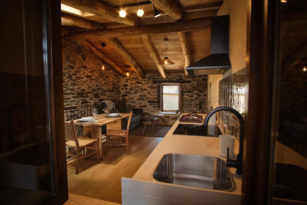 cocina con fregadero y mesa en una habitación en A Barreira -Lar da cima- en Folgoso