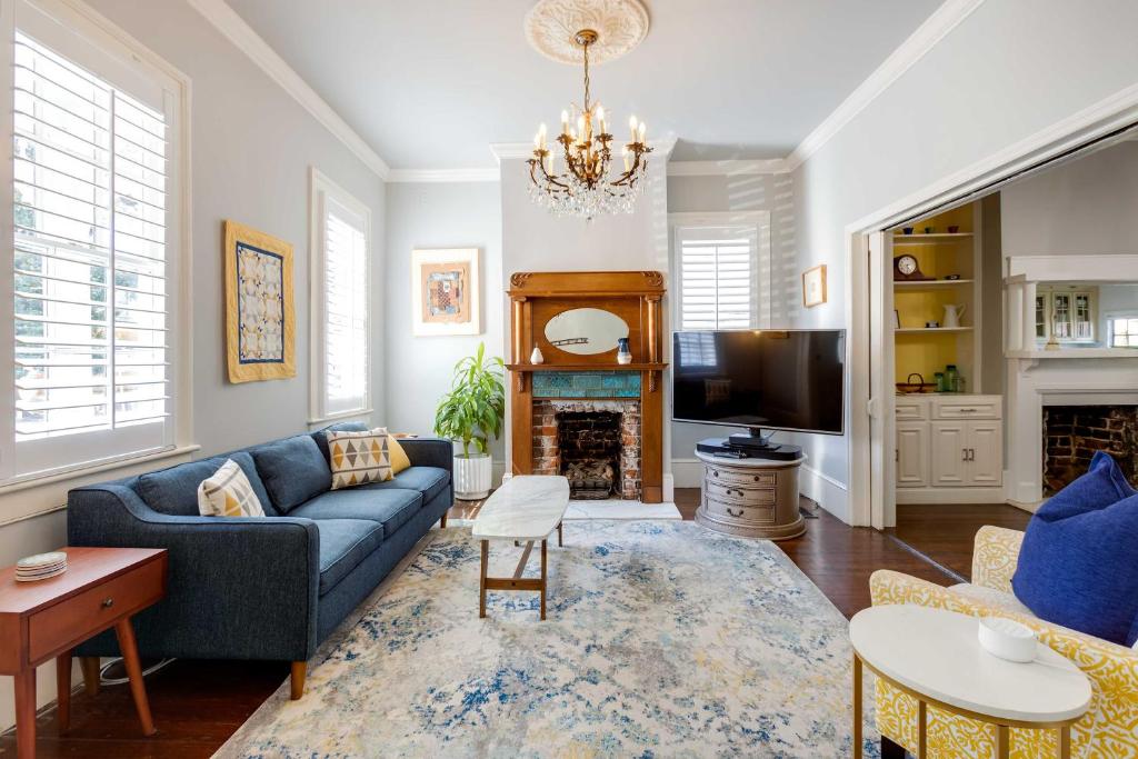 a living room with a blue couch and a fireplace at Historic Savannah Home with Outdoor Grill, Patio in Savannah