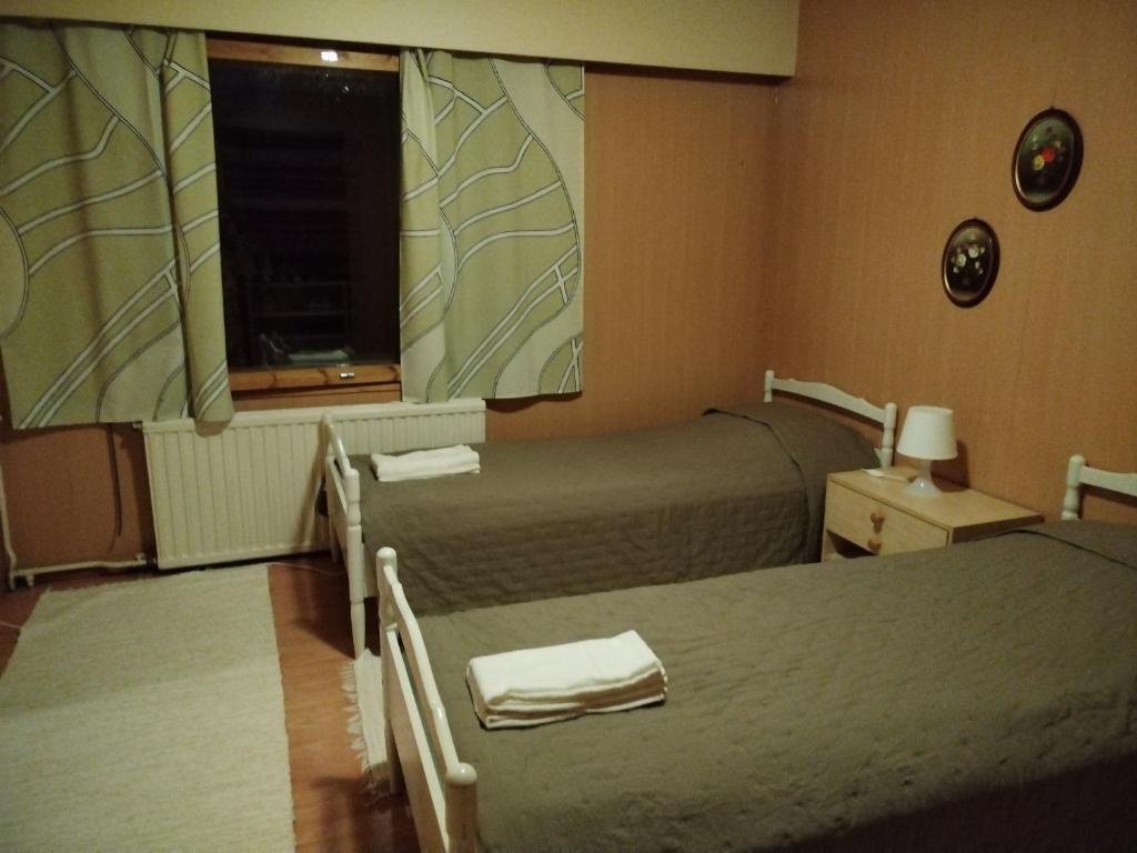 KannonkoskiにあるFormer Hotel Restaurant Kannonkrouviのベッド2台と窓が備わるホテルルームです。