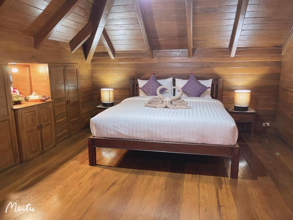 um quarto com uma cama grande e 2 candeeiros nas mesas em Lantana House em Ban Pa Muang