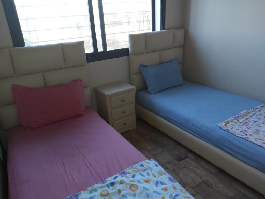 duas camas num quarto com duas almofadas em Residance Perla Bouznika em Bouznika