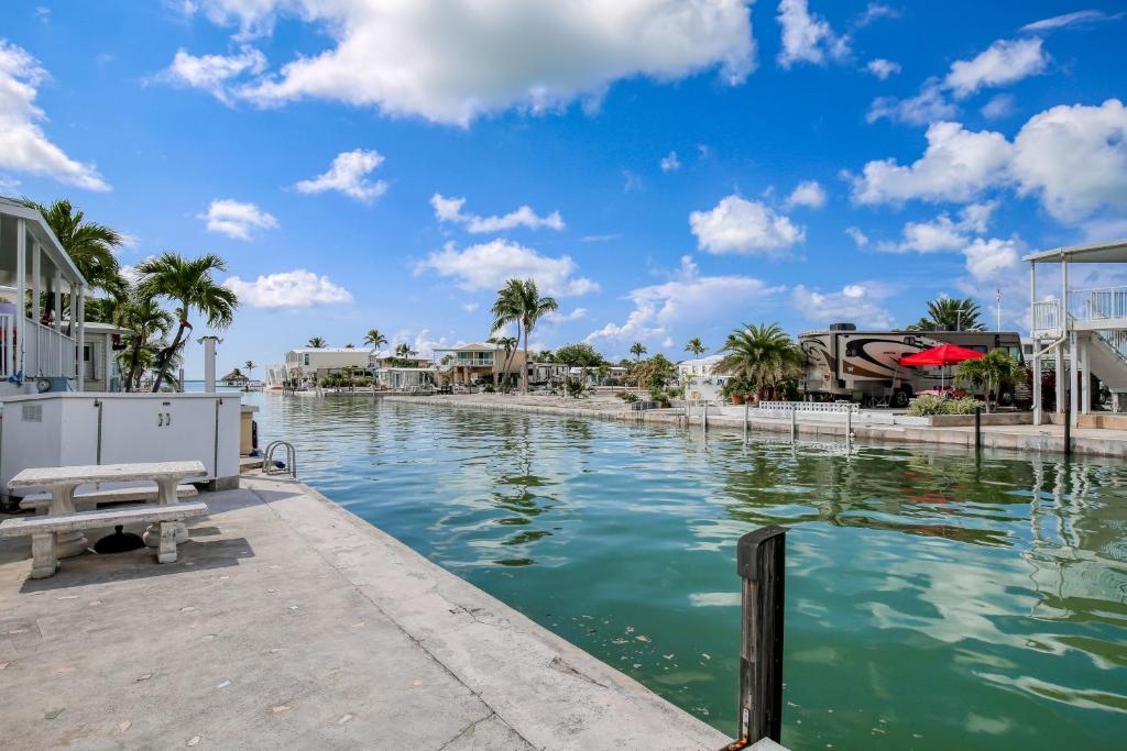 a pool of water with palm trees and houses at Dock Holiday in Cudjoe Key