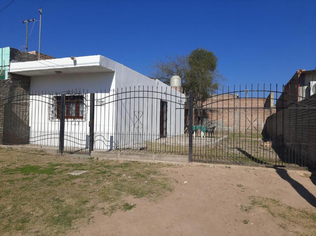una recinzione con una mucca di fronte a un edificio di La Termenia a Termas de Río Hondo