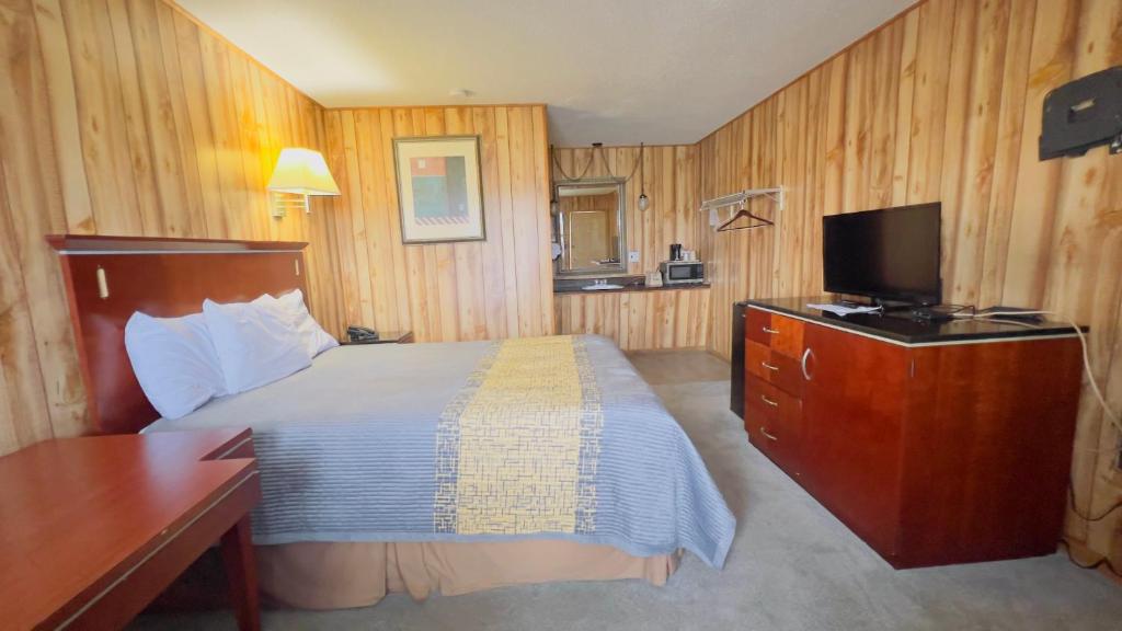 una habitación de hotel con una cama y un televisor en Country Inn - Licking, en Licking