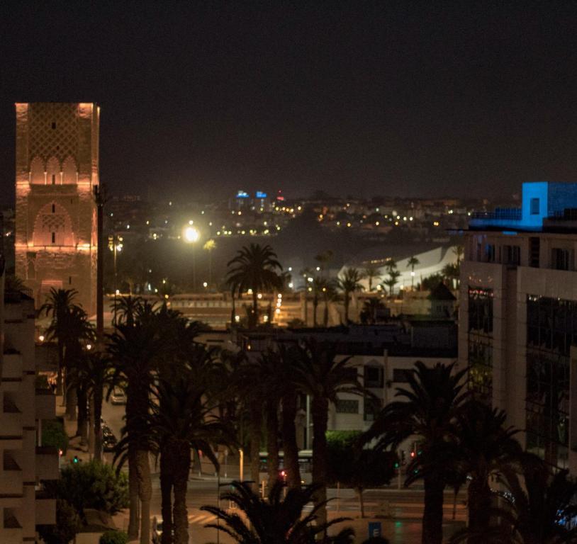 - une vue sur une ville de nuit avec des palmiers dans l'établissement Chambre des palmiers, à Rabat