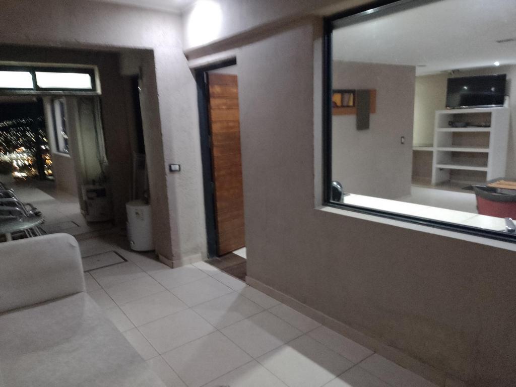 sala de estar con ventana y sofá en Altos Apart Carlos Paz en Villa Carlos Paz