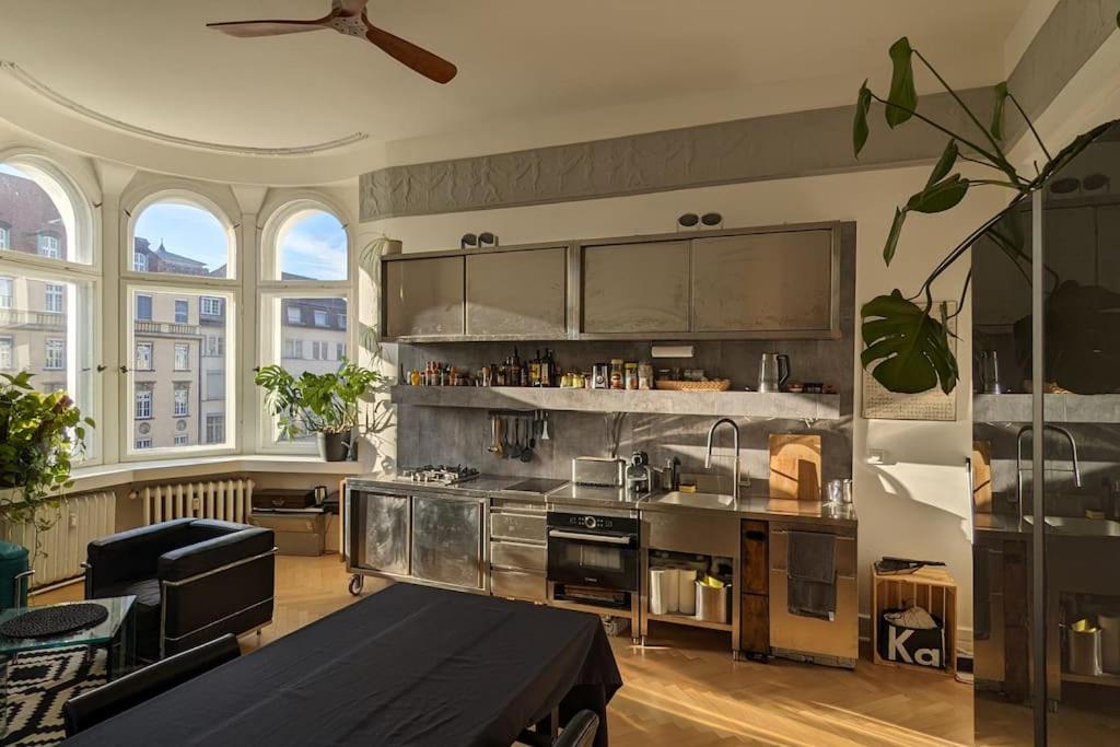 a large kitchen with stainless steel appliances and windows at Modern meets Classic - near Volkspark Schöneberg in Berlin