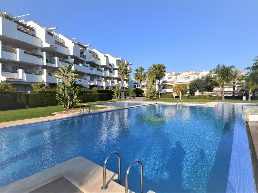 Los DolsesにあるLovely Apartment in Valencia near Seaのアパートメントの建物の前にスイミングプールがあります。