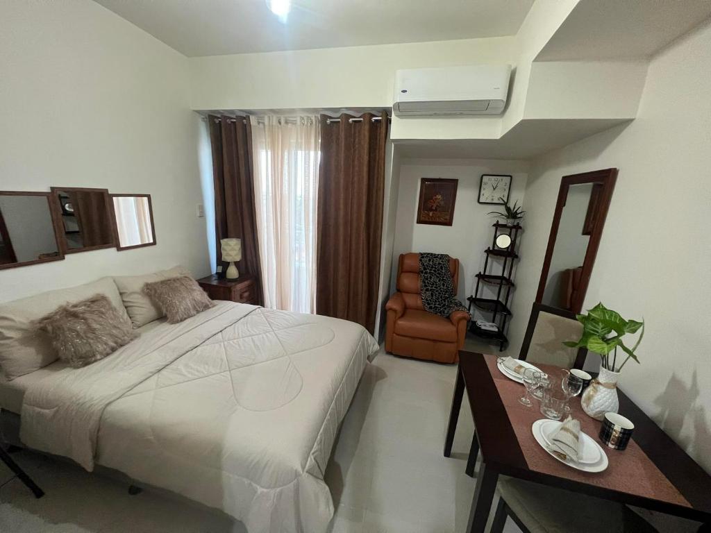 a bedroom with a bed and a table and a chair at Inspiria Condominium Tower, beside Abreeza Ayala Mall, Davao City in Davao City