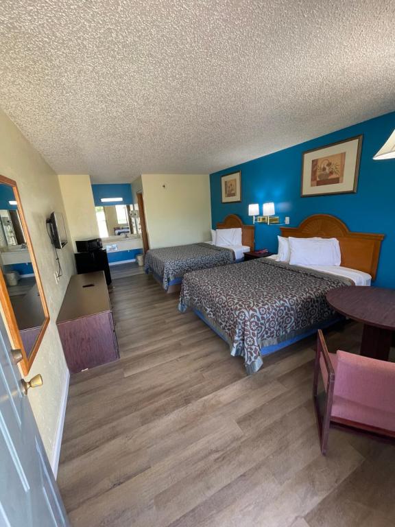 2 camas en una habitación de hotel con paredes azules en Executive Inn, en Mountain Home