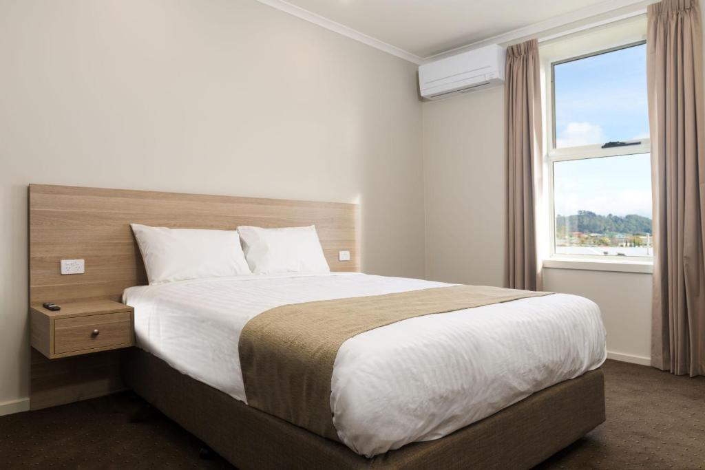 a bedroom with a large bed with a window at Somerset Hotel in Somerset