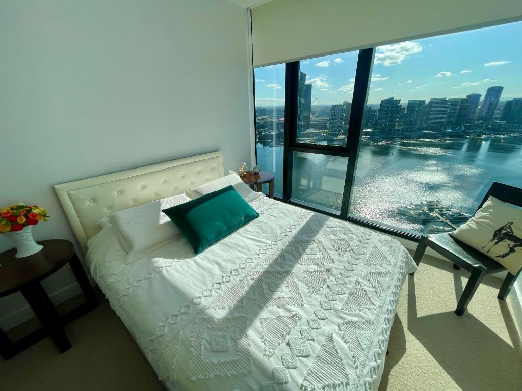 a bedroom with a bed and a large window at Yarra Accommodation in Melbourne