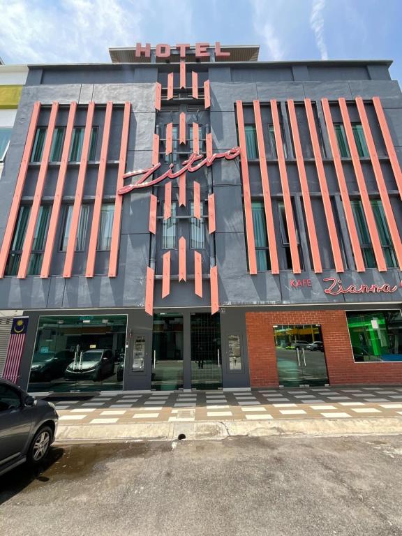 un grande edificio con un edificio con un'auto parcheggiata di fronte di Zitro Hotel a Port Dickson