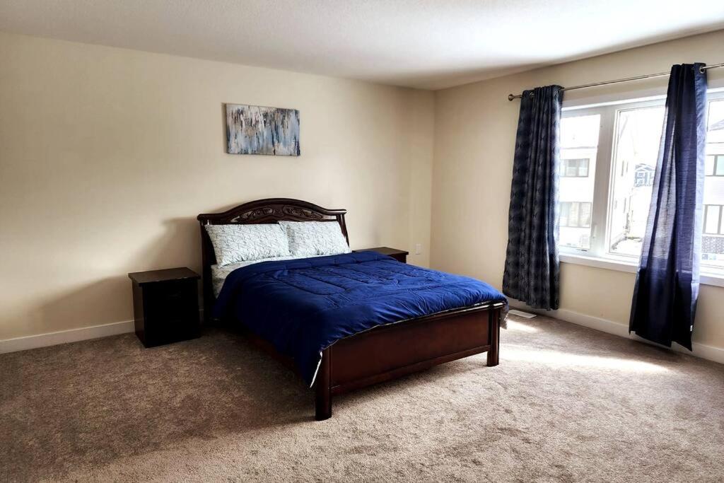 - une chambre avec un lit doté de draps bleus et une fenêtre dans l'établissement Entire home near Hamilton, à Caledonia