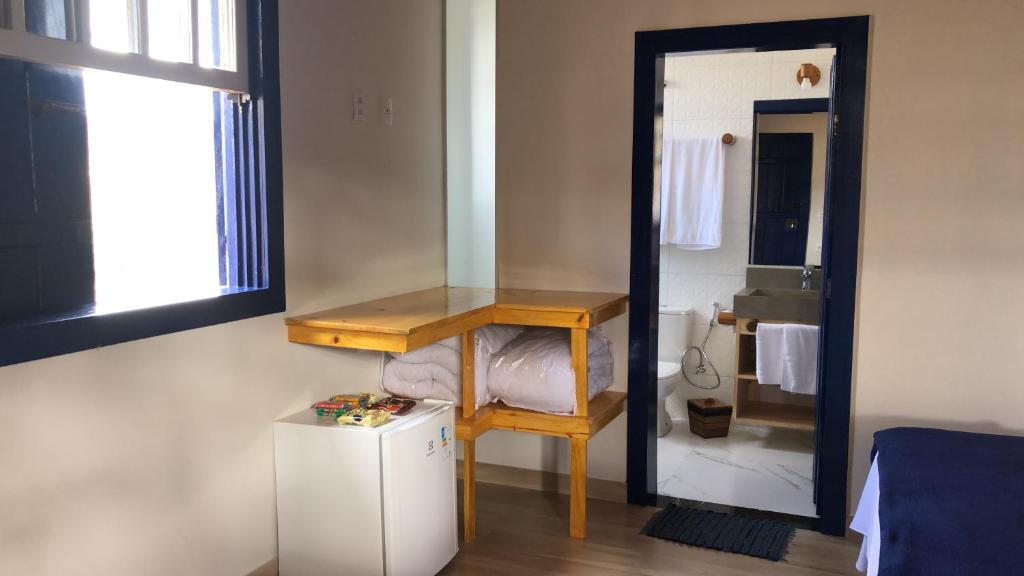 a room with a mirror and a table and a small refrigerator at Estância do Biribiri in Diamantina