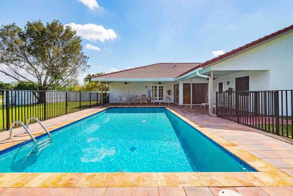 a swimming pool in the backyard of a house at 4/3.5 House with pool- Boynton Beach, FL. in Boynton Beach