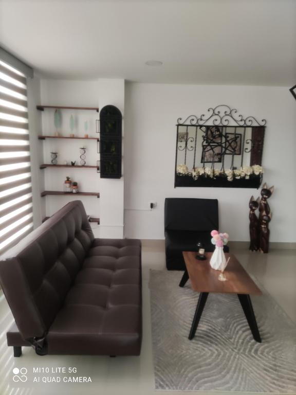 sala de estar con sofá de cuero y mesa de centro en Apartaestudio Maridiaz, en Pasto