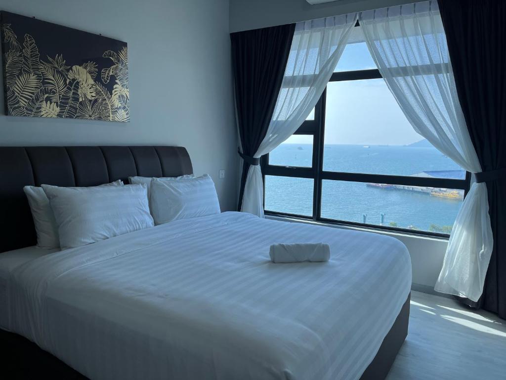 a bedroom with a large bed with a large window at Kota Kinabalu Jesselton Quay Sea View with washing machine in Kota Kinabalu