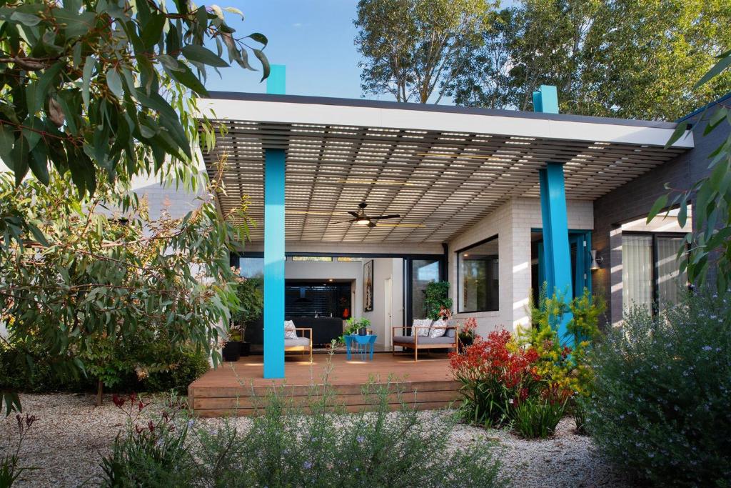 une maison avec une terrasse dotée de colonnes bleues dans l'établissement Arenas South, à Daylesford