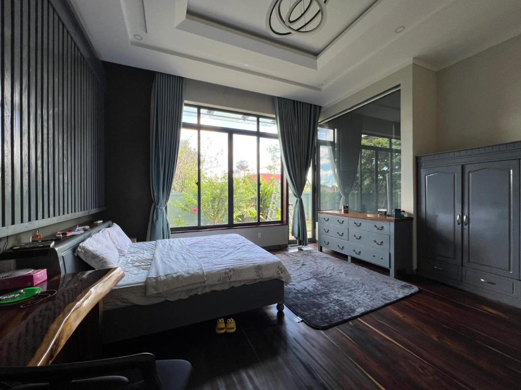 1 dormitorio con 1 cama, vestidor y ventana en Ylang Farmstay, en Buon Ma Thuot