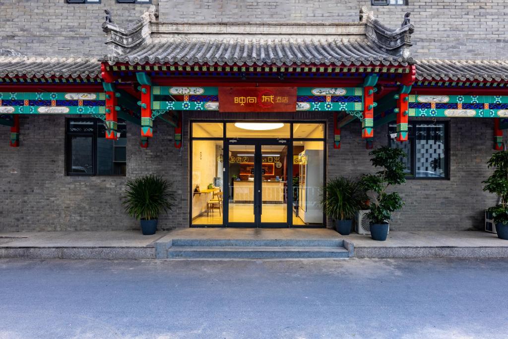 uma entrada para um edifício com uma porta amarela em Happy Dragon Hotel - close to Forbidden City&Wangfujing Street&free coffee &English speaking,Newly renovated with tour service em Pequim