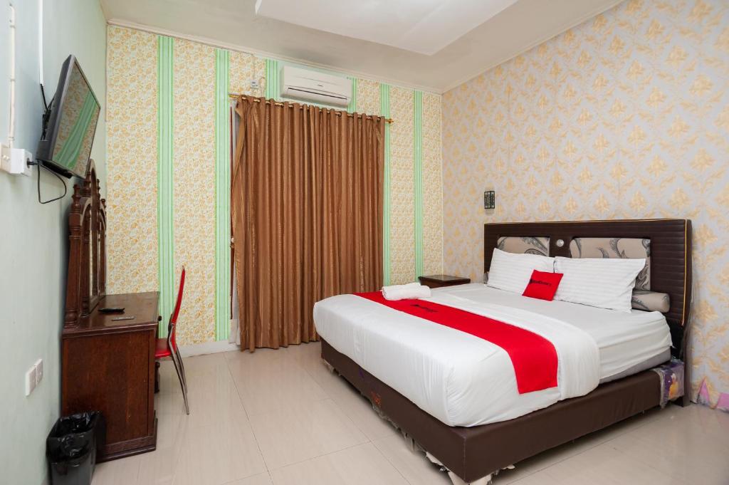 Säng eller sängar i ett rum på RedDoorz Syariah at Bumi Siliwangi Residence Padang