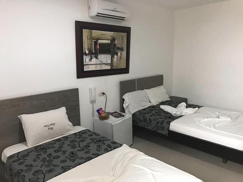 מיטה או מיטות בחדר ב-Hotel Madrid Deluxe Neiva