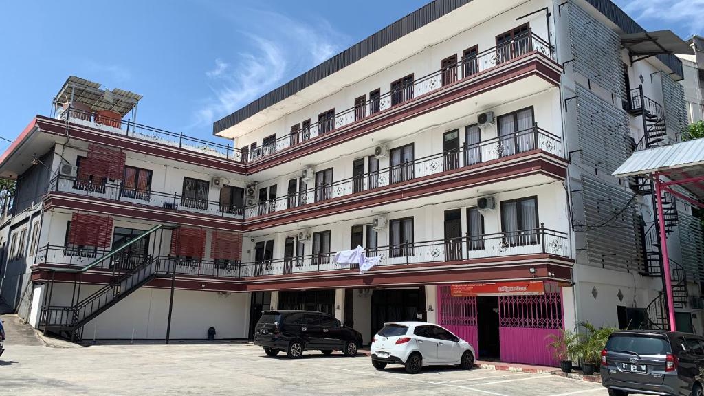 um carro branco estacionado em frente a um edifício em OYO 92865 Guest House Pandita em Sebawang