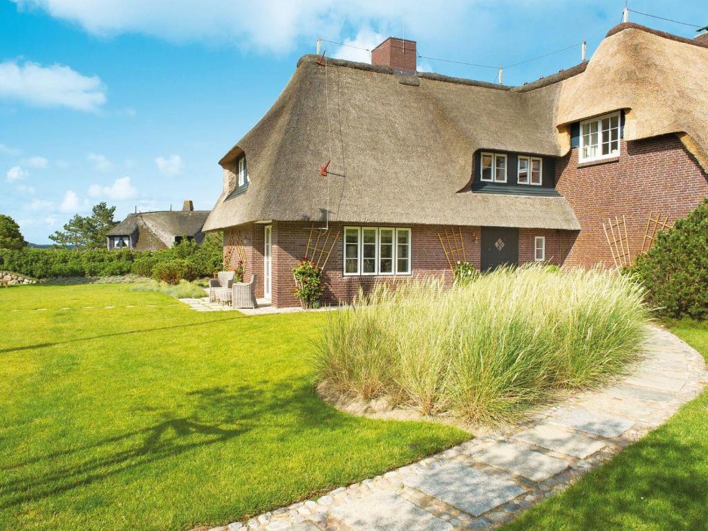 a house with a thatched roof and a grass yard at Nug-Pot-House in Kampen