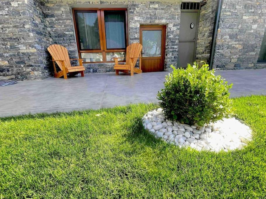 duas cadeiras e um arbusto em frente a um edifício em Akbay Home Bozcaada mini. Denize 500 mt em Bozcaada