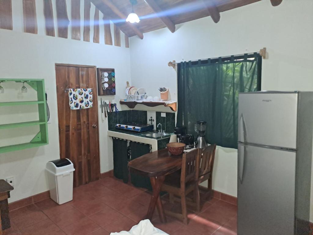 a kitchen with a small table and a refrigerator at Casa Rosada Nosara in Nosara