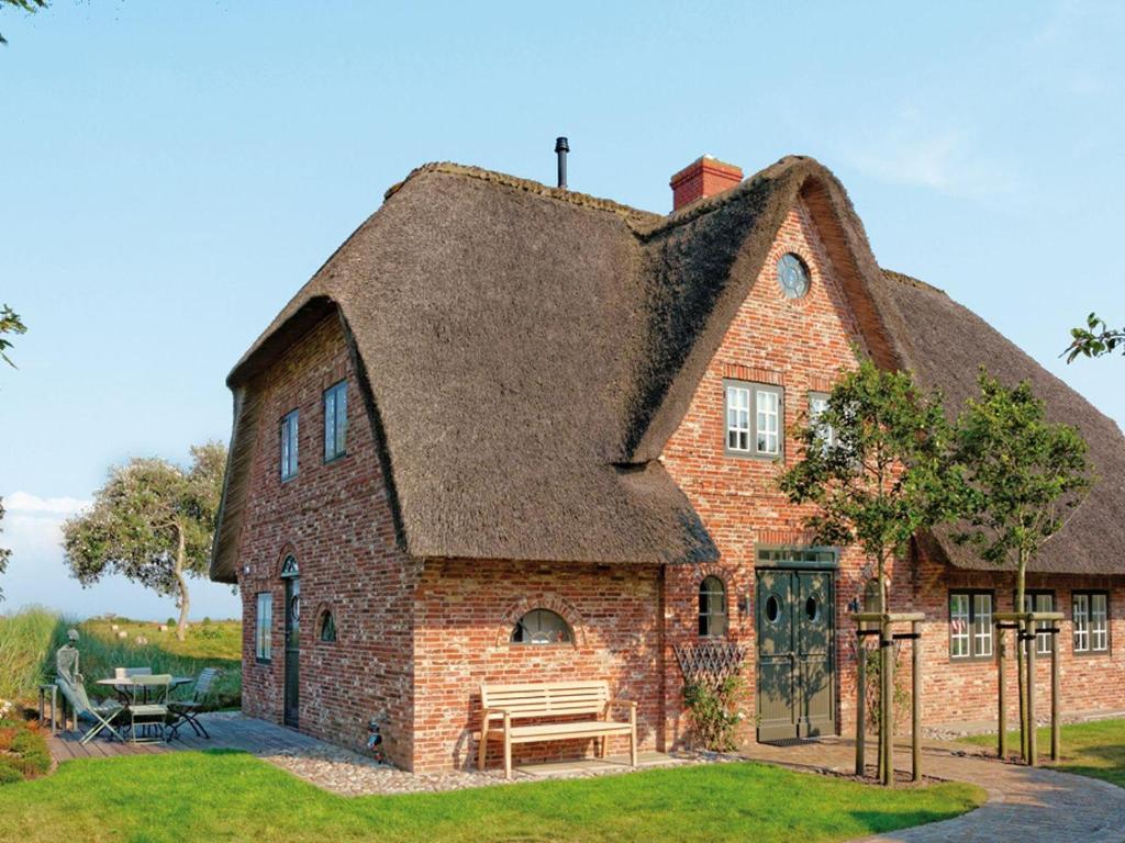 Cette grande maison en briques est dotée d'un toit de chaume. dans l'établissement Haus-zum-Leuchtturm, à Kampen