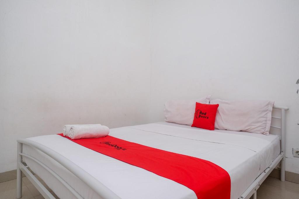 Кровать или кровати в номере RedDoorz at Golden White House Pettarani